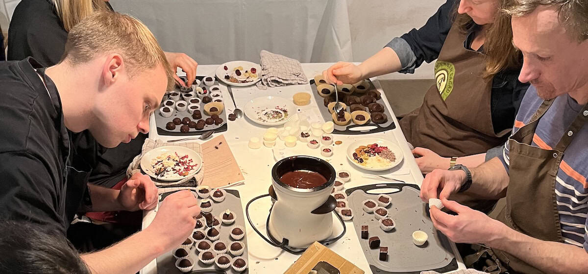 Deltagere i chokoladeworkshop laver håndlavet chokolade.
