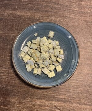 Guld frankincense i en blå skål på træbord.