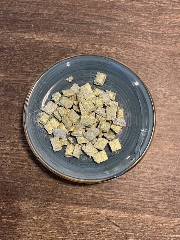Guld frankincense i en blå skål på træbord.
